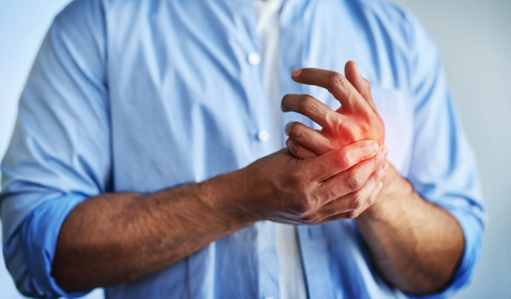 Individual holding his hand due to nerve pain from peripheral neuropathy, a condition treated with Class IV laser therapy at BionwoRx in Carmel, Indiana